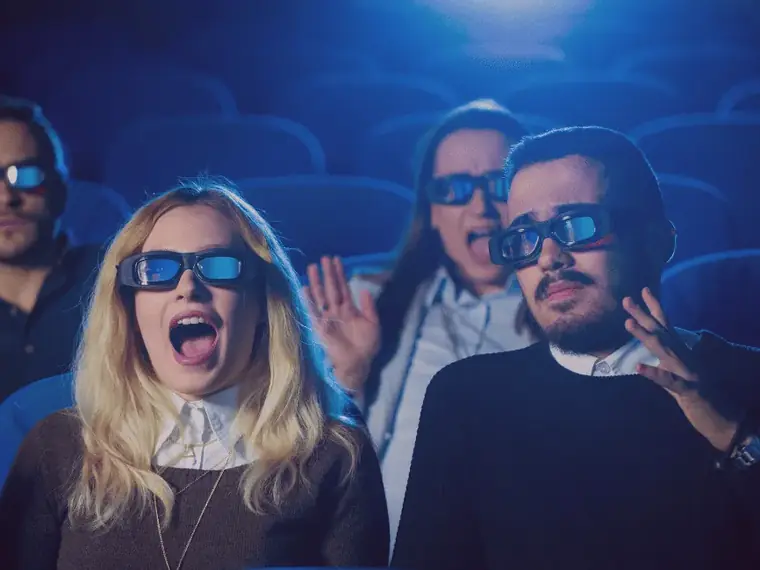 Casal com óculos 3D em sessão de cinema