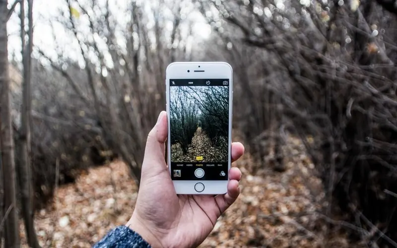 Mãos com celular e câmera