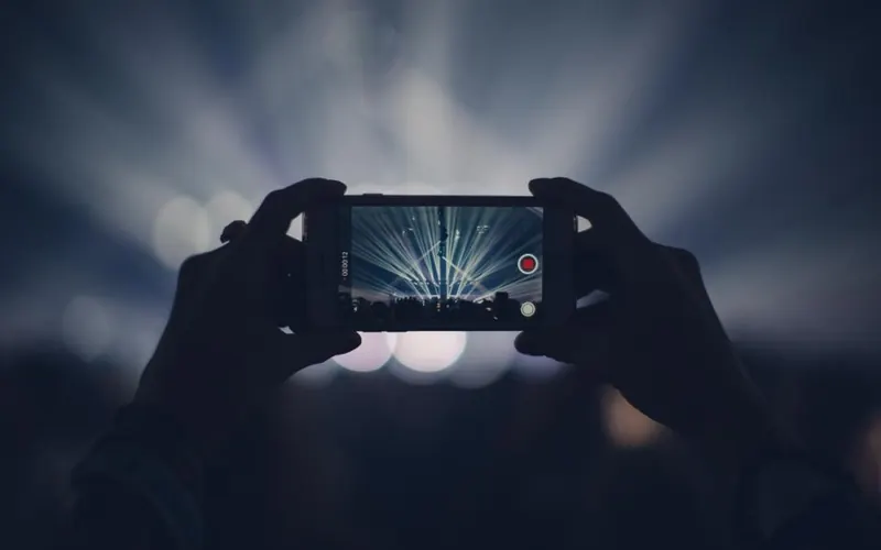Mãos com celular em um show