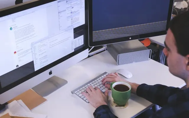 Pessoas com computador e café no escritório
