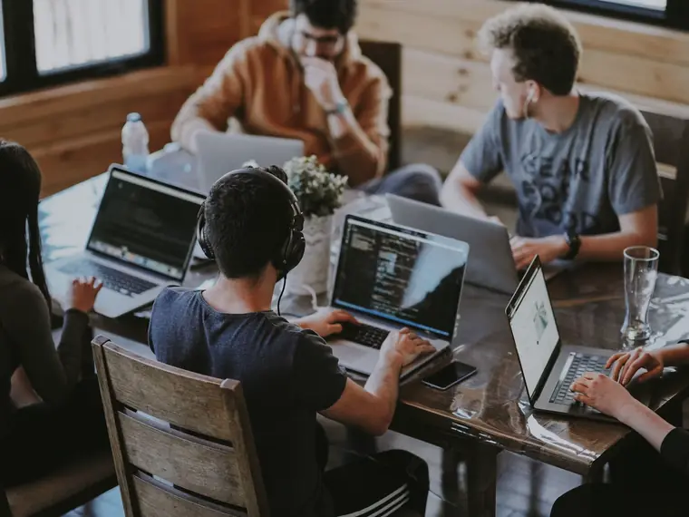 Pessoas trabalhando com notebooks em uma mesa