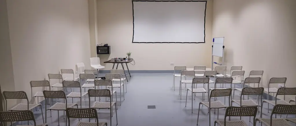 Sala com projetor no teto e tela de projeção