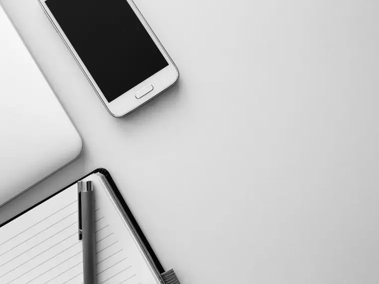 Smartphone sobre um caderno em mesa clara