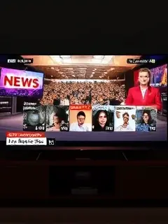 Televisão exibindo noticiário em sala escura